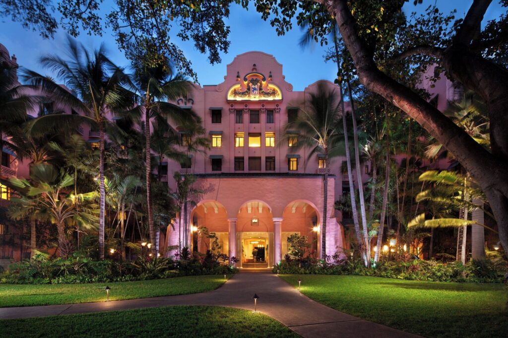 Exterior view of The Royal Hawaiian, a Luxury Collection Resort in Waikiki, featuring iconic pink architecture, beachfront luxury, tropical gardens, and classic Hawaiian resort elegance.