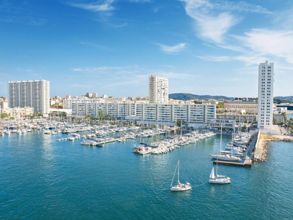Walking along Toulon harbor with boats and waterfront views