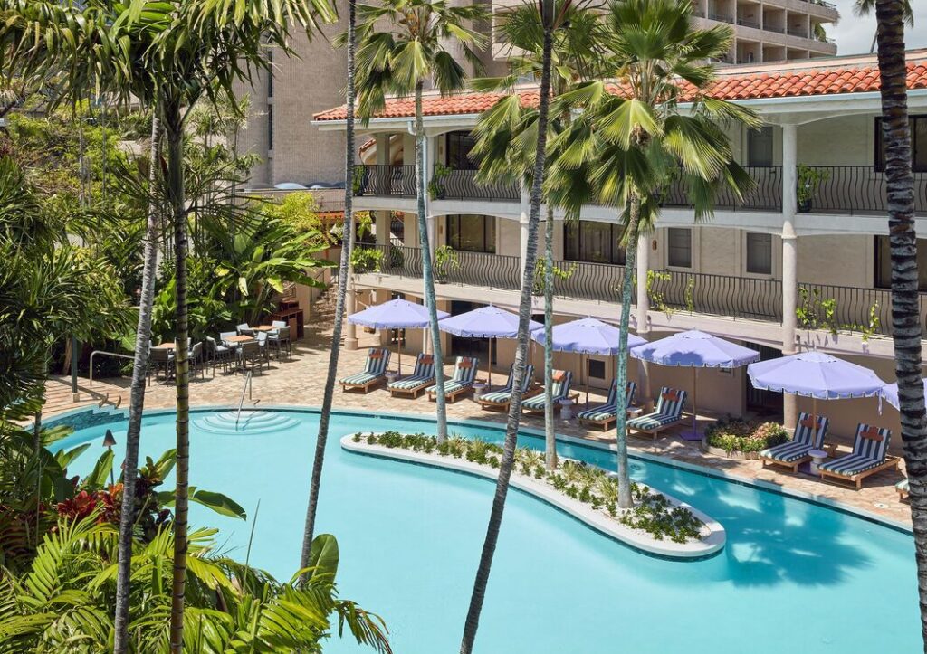 Exterior view of Wayfinder Waikiki in Waikiki, featuring retro-modern design, tropical pool courtyard, boutique-style accommodations, and a vibrant island-inspired atmosphere.