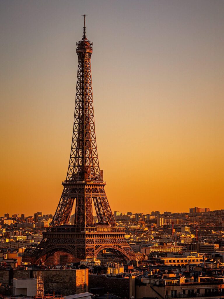 Eiffel Tower during sunset with warm golden light over Paris skyline