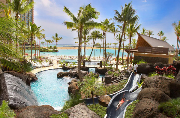 Tropical beachfront view of Hilton Hawaiian Village Waikiki Beach Resort with palm trees and Waikiki ocean scenery