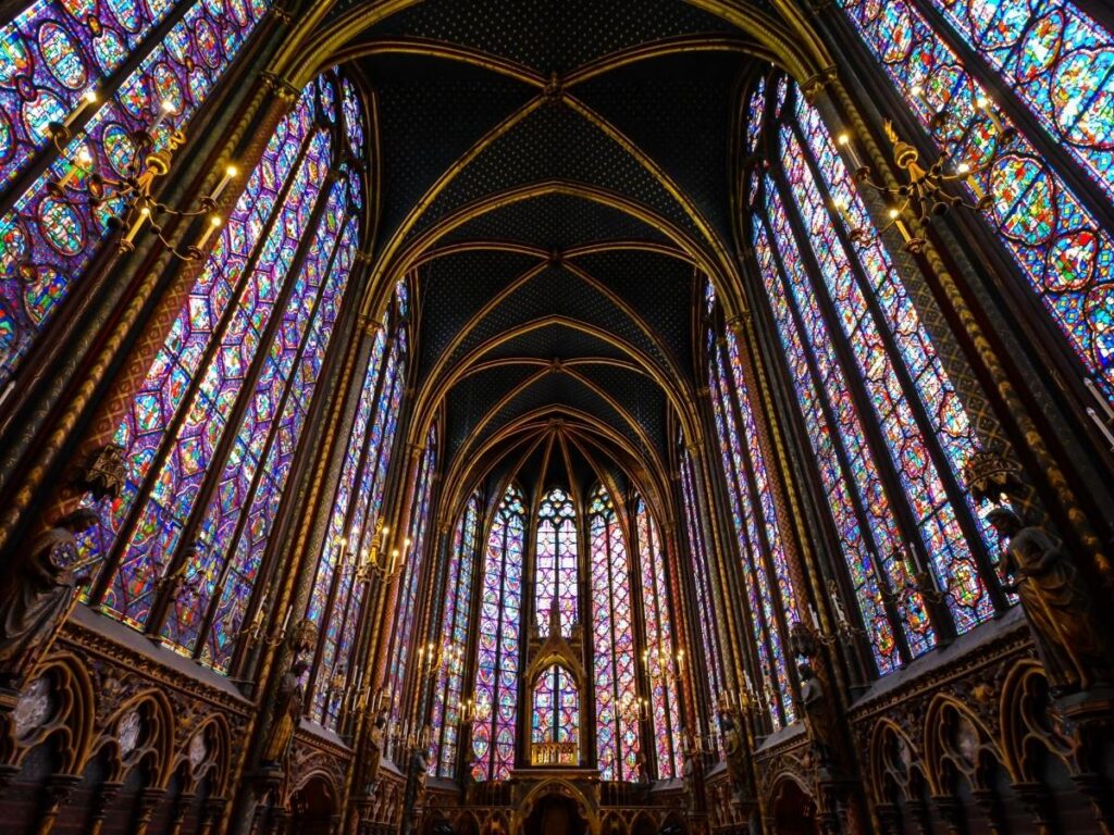 Visitor admiring stained glass inside Metz Cathedral