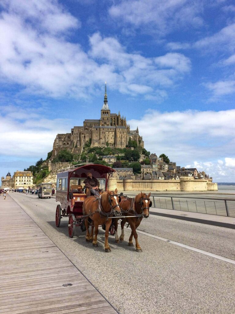 Visitors approaching Mont Saint Michel during a day trip in Normandy