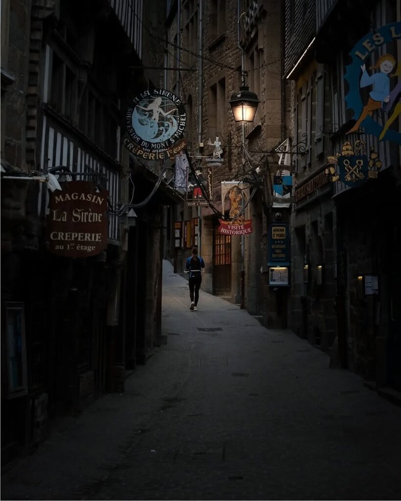 Medieval street glowing at night in Mont Saint Michel