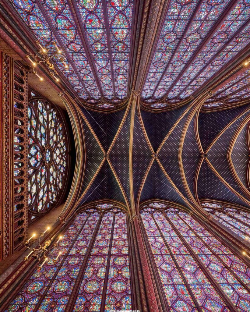 Detailed stained glass scenes inside Sainte-Chapelle in Paris