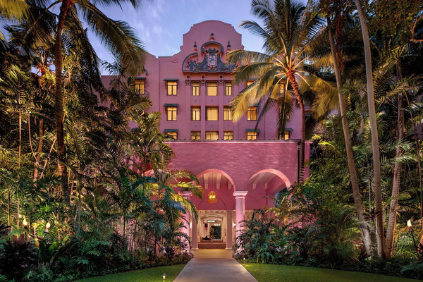 Historic pink beachfront facade of The Royal Hawaiian, a Luxury Collection Resort overlooking Waikiki Beach with iconic luxury resort architecture in Hawaii.