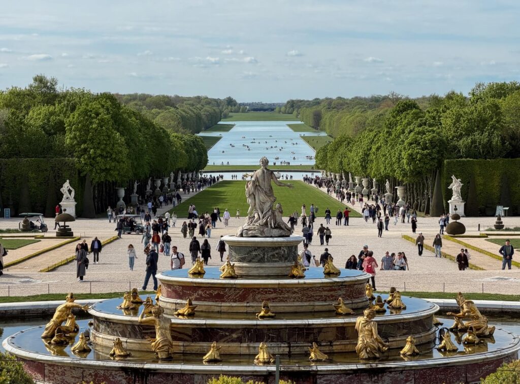Busy courtyard at the Palace of Versailles with large crowds of visitors