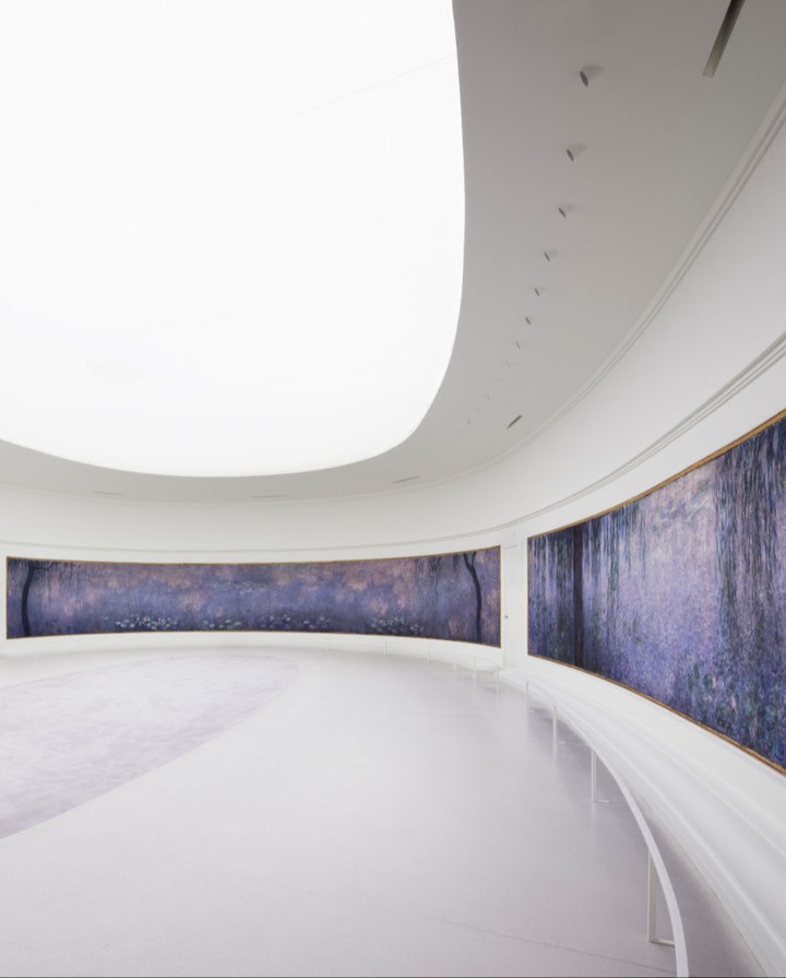 Visitor sitting inside Monet Water Lilies gallery in Paris