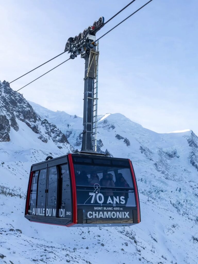 Aiguille du Midi cable car traveling above cliffs and glaciers near Chamonix