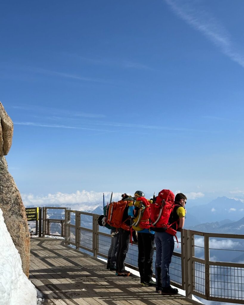 Visitors enjoying panoramic mountain views from the Aiguille du Midi summit terrace