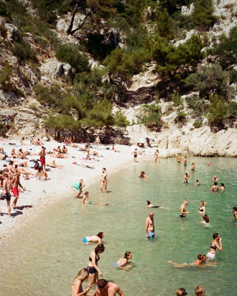 Visitors swimming in Calanque d'En-Vau during summer