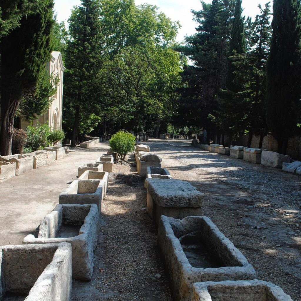 Tree-lined pathway and Roman sarcophagi at Alyscamps in Arles