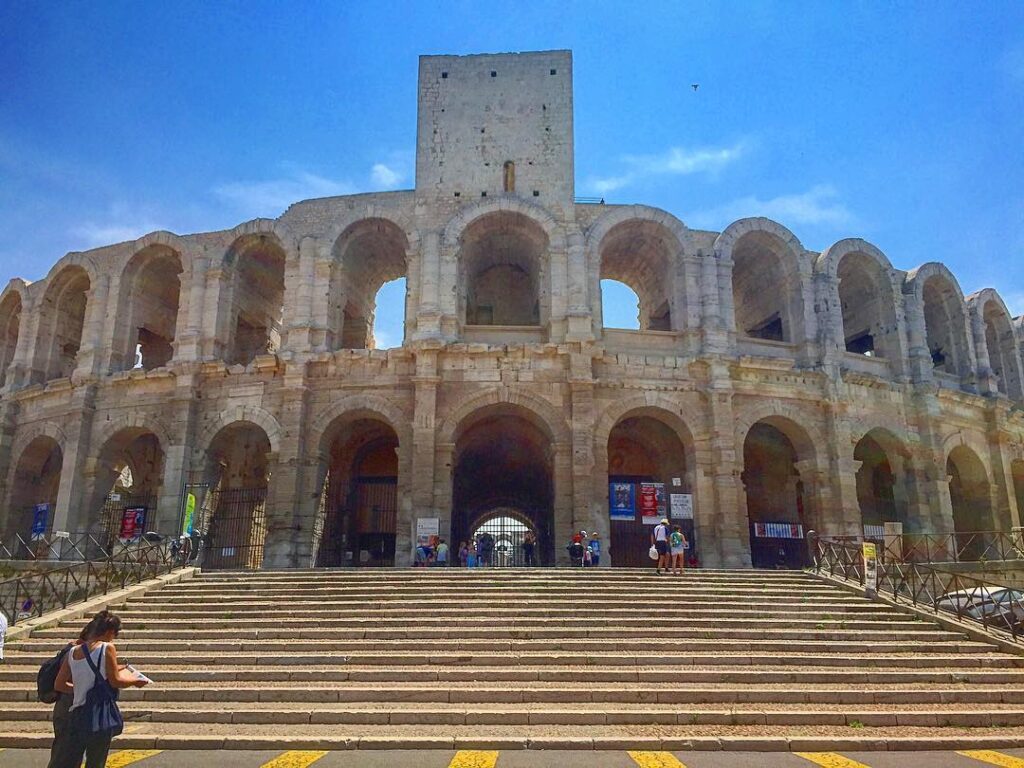 Visitors exploring the historic center of Arles during summer