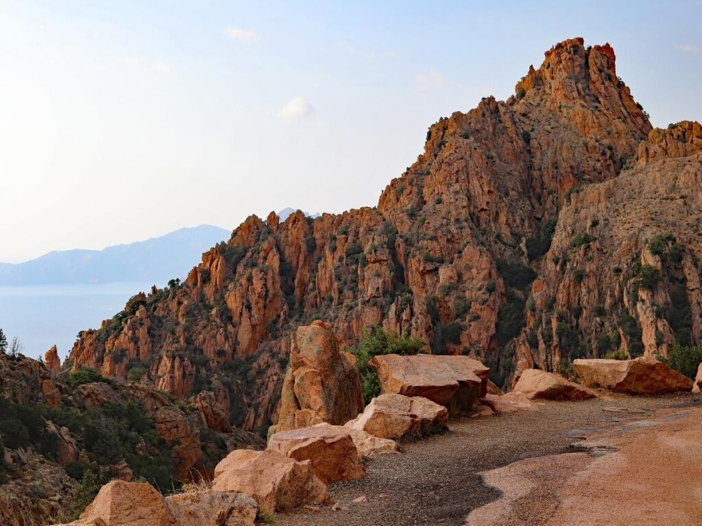 The scenic D81 road winding through the red rock formations of the Calanques de Piana