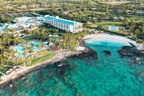 Oceanfront scenery at Fairmont Orchid on Hawaii's Big Island, featuring a tranquil white-sand lagoon, tropical gardens, luxury accommodations, swaying palm trees, and breathtaking Pacific Ocean views.