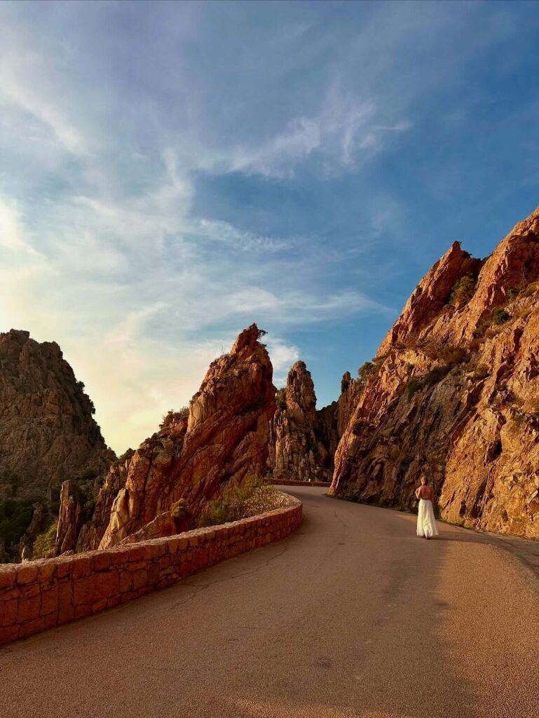 Golden evening light illuminating the red granite cliffs of the Calanques de Piana