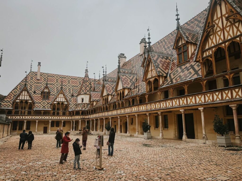 Courtyard of Hospices de Beaune surrounded by colorful Burgundy tiled roofs