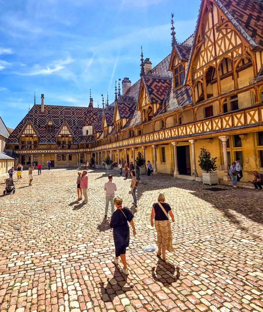 Early morning view of Hospices de Beaune courtyard and colorful tiled roofs