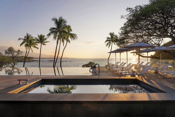 Historic luxury beachfront view of Mauna Kea Beach Hotel, Autograph Collection, featuring elegant oceanfront accommodations, a crescent-shaped white-sand beach, lush tropical landscaping, and stunning Pacific Ocean scenery that reflects the resort’s timeless Hawaiian heritage.