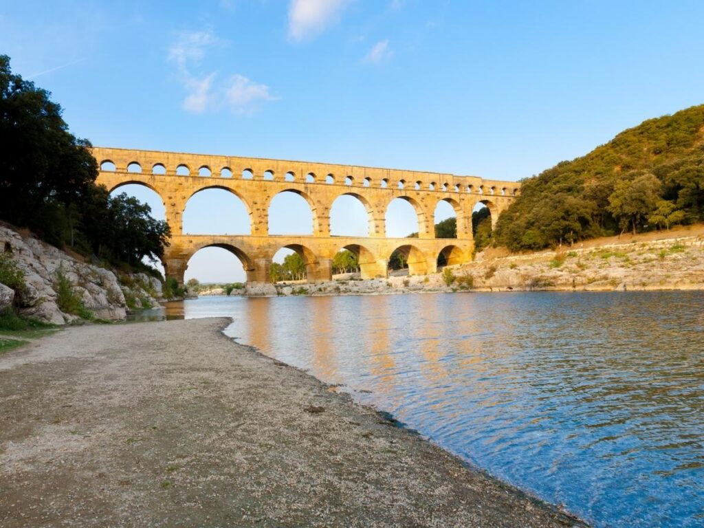 Pont du Gard reflected in the Gardon River from the riverside viewpoint