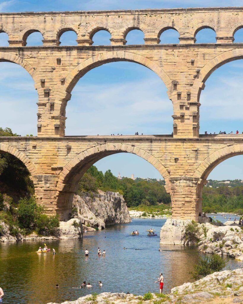Families enjoying the Gardon River near Pont du Gard on a summer day