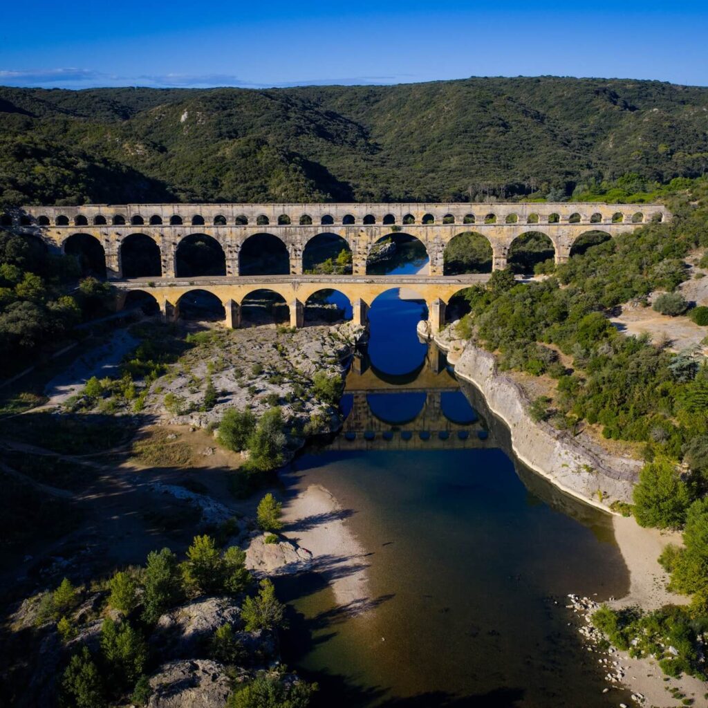 Visitors exploring riverside walking trails near Pont du Gard