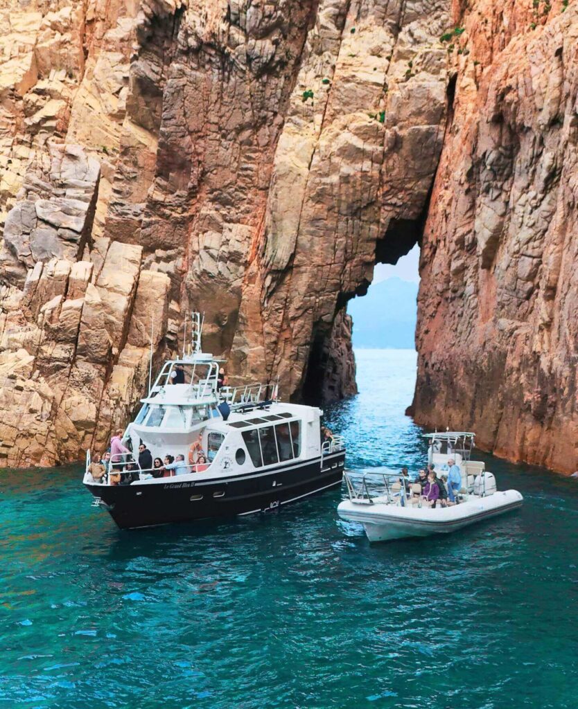 Boat tour cruising along the cliffs of Scandola Nature Reserve in Corsica