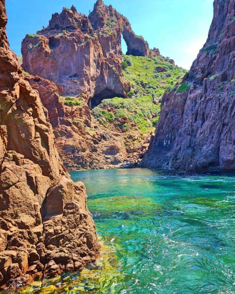 Towering red volcanic cliffs rising from the Mediterranean in Scandola Nature Reserve