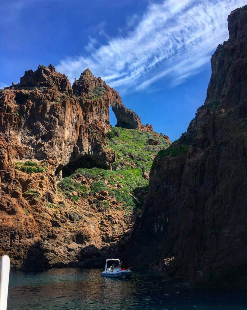 Green coastal landscape and volcanic cliffs in Scandola Nature Reserve during spring