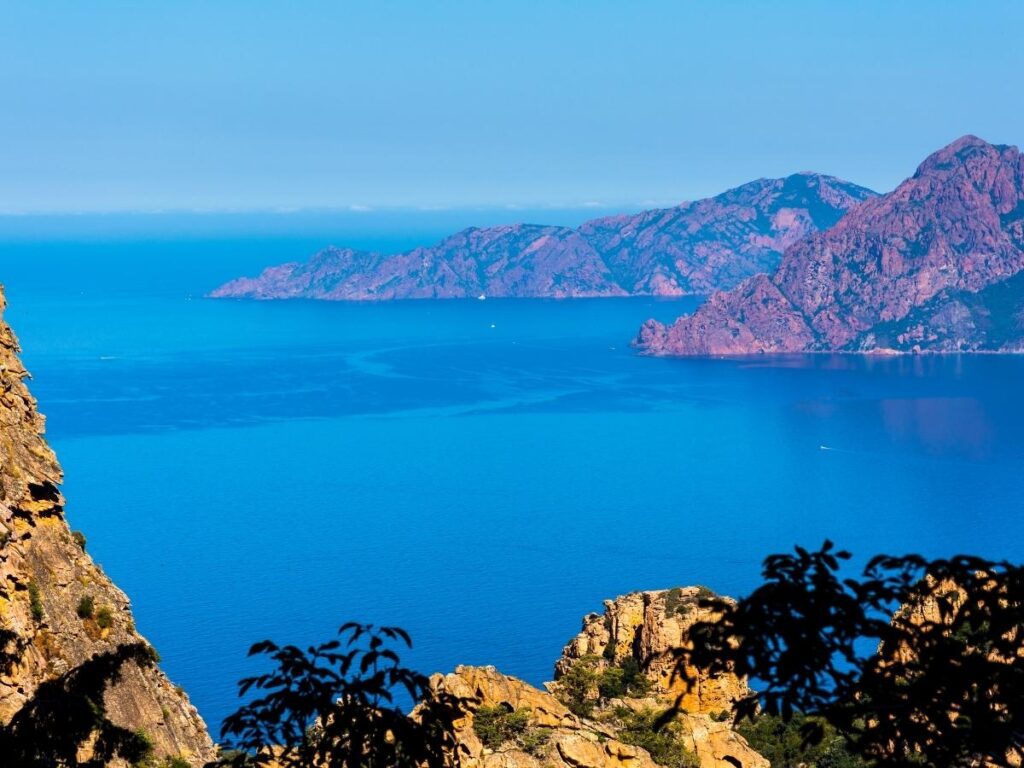 Dramatic red volcanic cliffs and rugged coastline in Scandola Nature Reserve