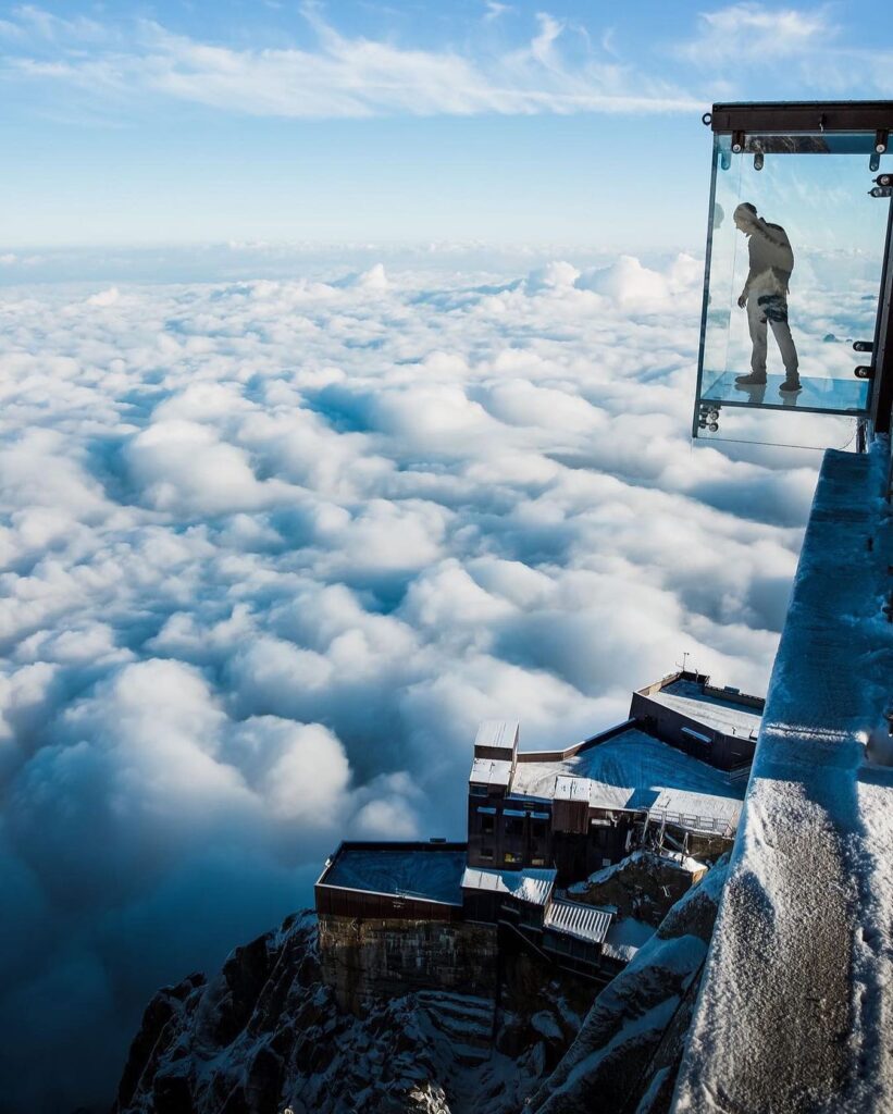 Visitor standing inside the Step Into the Void glass skybox at Aiguille du Midi