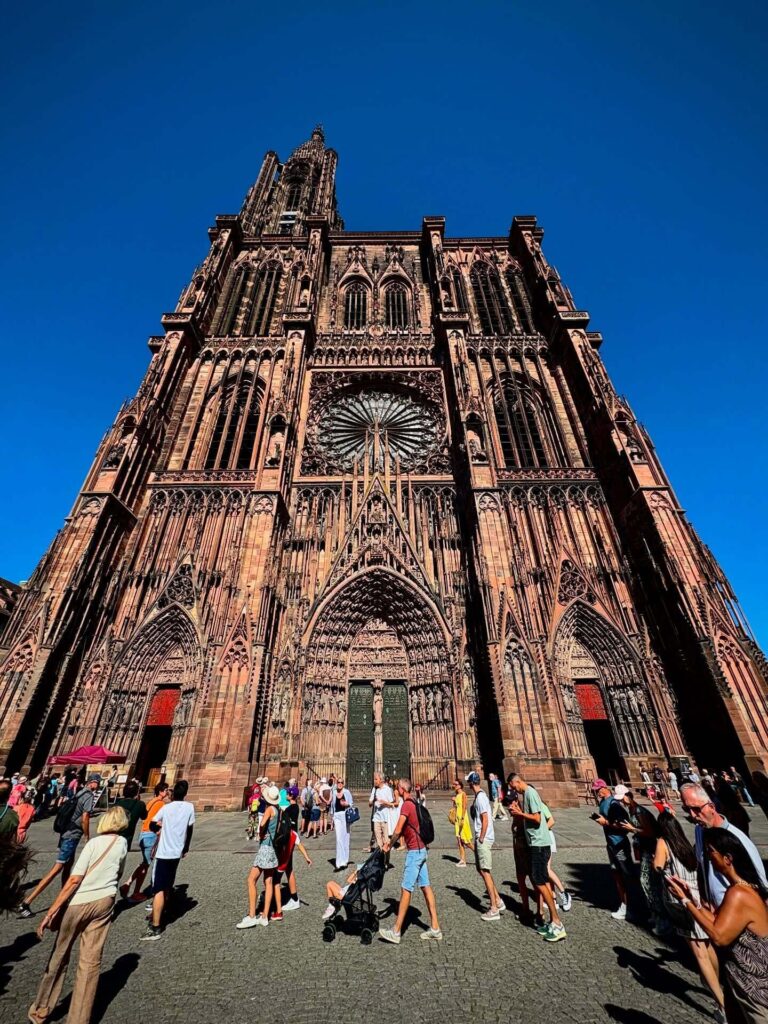 Main entrance of Strasbourg Cathedral with visitors arriving