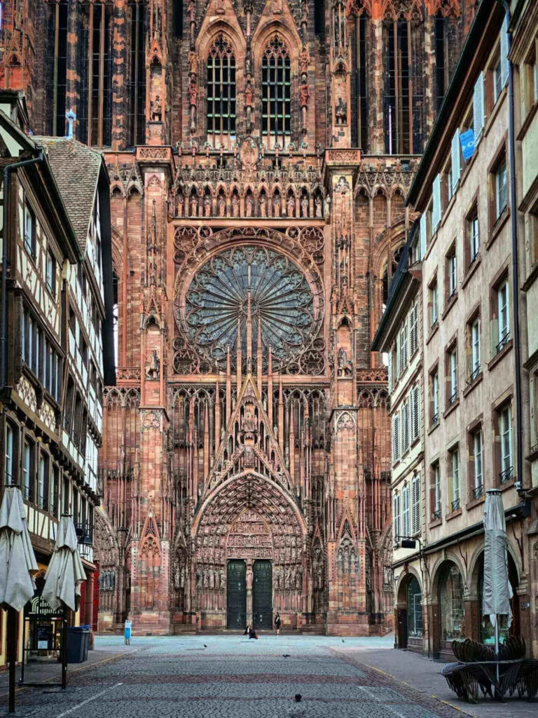 Pink sandstone facade of Strasbourg Cathedral with intricate Gothic details