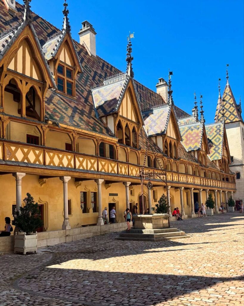 Visitors exploring the courtyard of Hospices de Beaune