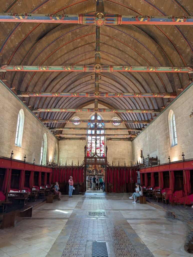 Visitors exploring the historic rooms inside Hospices de Beaune