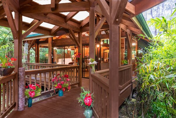 Volcano Village Lodge in Hawaii, featuring a private bungalow surrounded by lush rainforest, elegant wood interiors, tranquil garden views, and a secluded retreat near Hawaiʻi Volcanoes National Park.