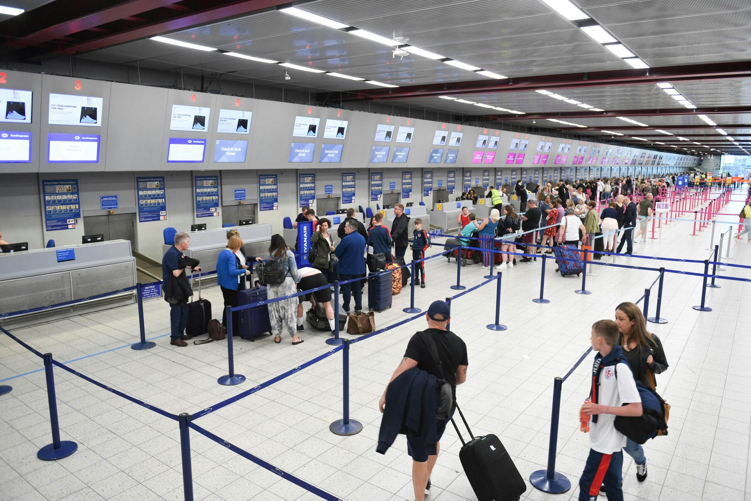 Travelers wait in a long EES border control line at a European airport