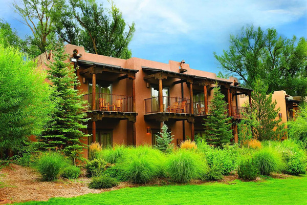 Exterior view of El Monte Sagrado Living Resort & Spa featuring luxurious adobe-inspired architecture and beautifully landscaped grounds.