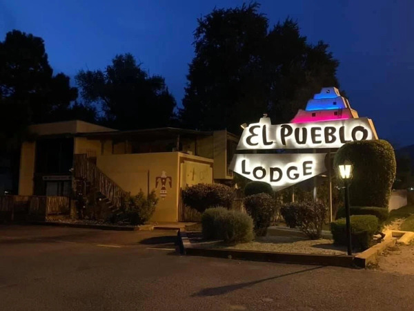 Welcoming entrance of El Pueblo Lodge with traditional Southwestern design and charming adobe details.