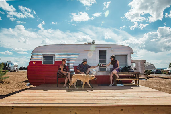 Exterior view of Hotel Luna Mystica featuring restored vintage trailers with the Sangre de Cristo Mountains in the background.
