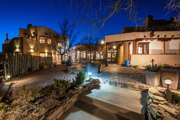 Exterior view of Inn on La Loma Plaza featuring historic adobe-style architecture and charming Southwestern landscaping in Taos, New Mexico.