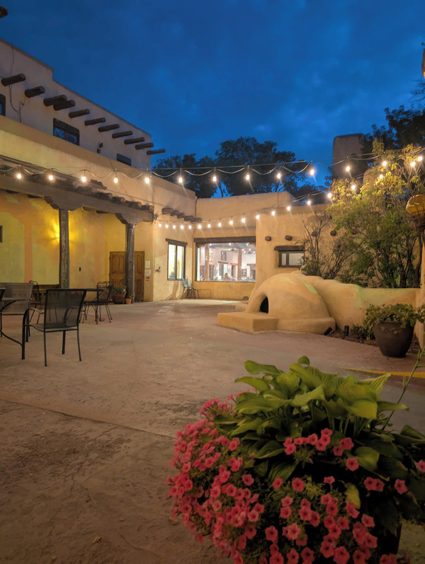 Exterior view of Sagebrush Inn & Suites featuring classic Southwestern adobe architecture and beautifully landscaped grounds in Taos, New Mexico.