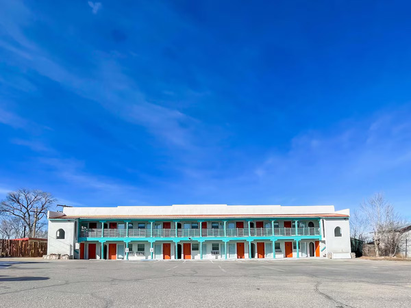 Exterior view of Taos Motor Lodge featuring a modern retro-inspired design with scenic mountain surroundings in Taos, New Mexico.
