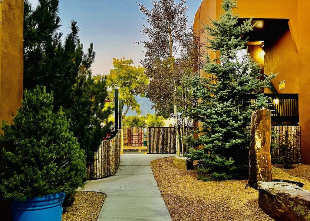 Exterior view of Taos Valley Lodge featuring classic Southwestern architecture and mountain surroundings.