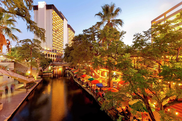 Exterior view of Hilton Palacio del Rio in San Antonio, featuring its distinctive modern architecture, elegant facade, and prime location along the San Antonio River Walk in downtown San Antonio.