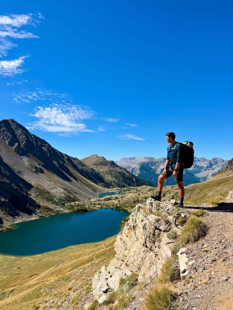 Hikers exploring an alpine trail near a mountain lake in Mercantour National Park