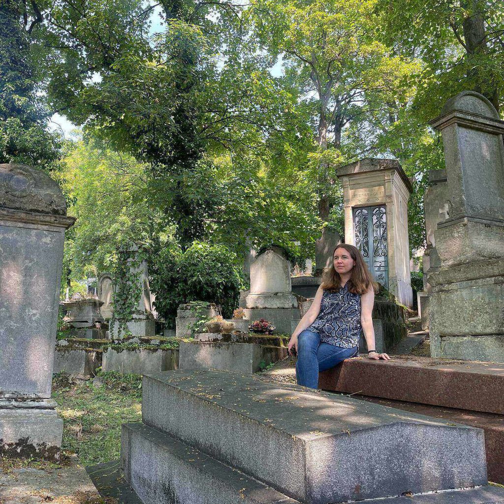 Visitors walking among the historic graves at Père Lachaise Cemetery in Paris