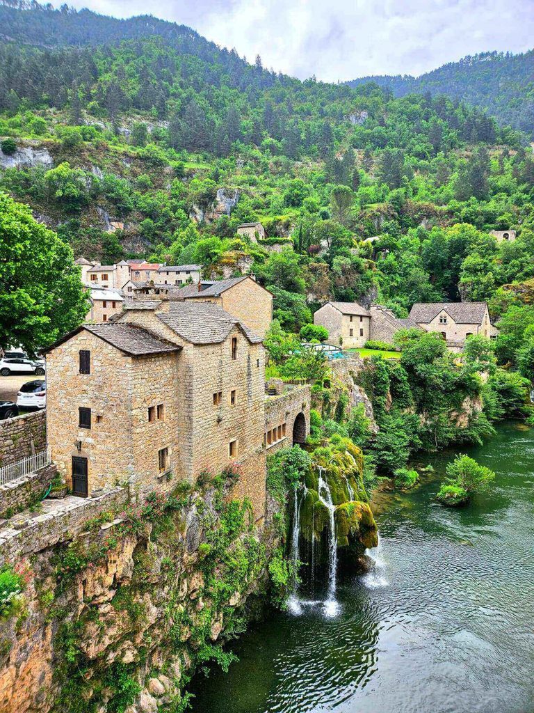 A wider view showing the village, stone bridge and river.