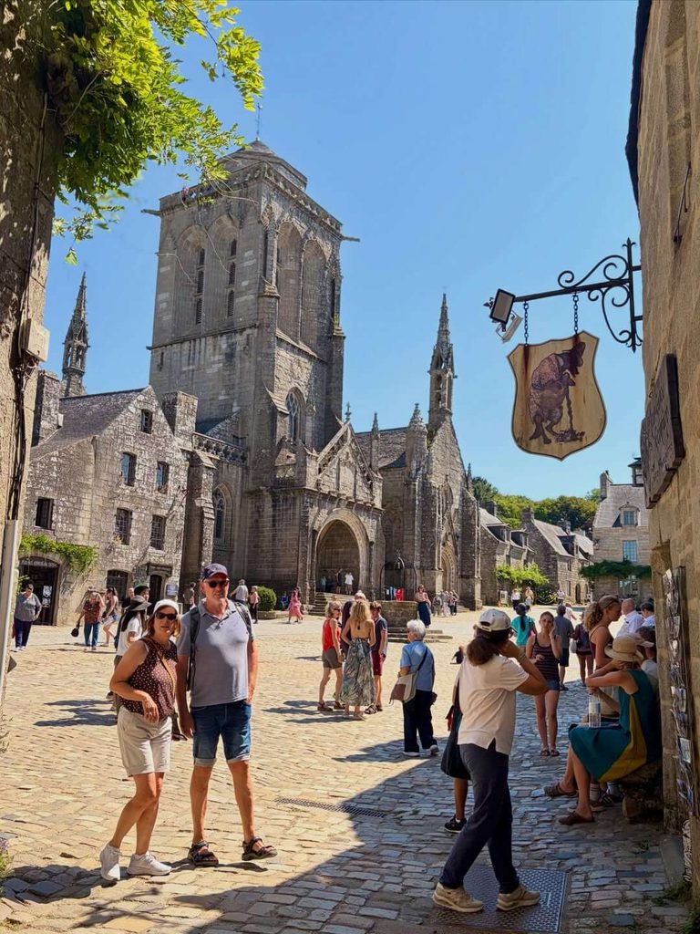 Visitors exploring Place de l’Église in Locronan