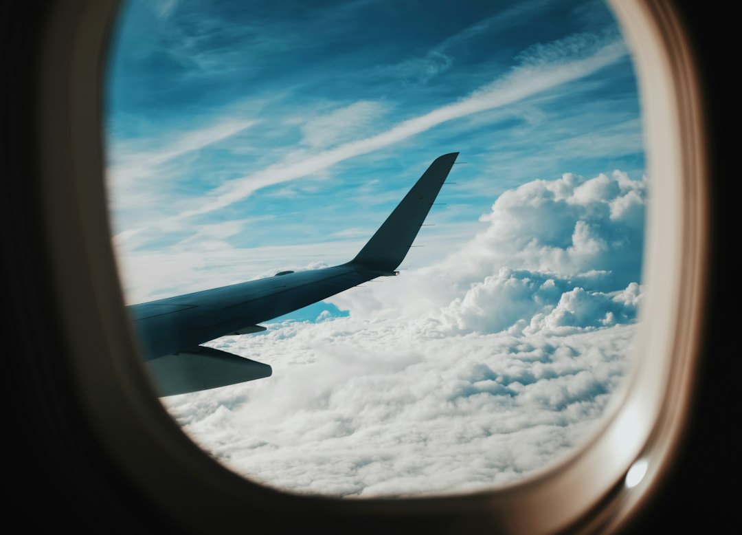 View of an airplane wing above the clouds from a window seat